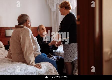 Figlia che frequenta la madre anziana con Alzheimer Foto Stock