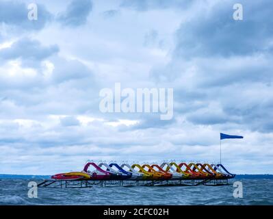 Vista sulle pedalò d'acqua barche da spiaggia sul lago Balaton in una giornata di tempesta. Foto Stock