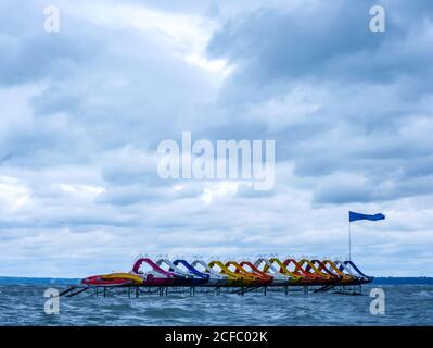 Vista sulle pedalò d'acqua barche da spiaggia sul lago Balaton in una giornata di tempesta. Foto Stock