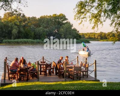 TISZAFURED, UNGHERIA - 08 AGOSTO 2020: Vista delle persone che cenano presso il lago Tisza a Tiszafured, Ungheria in un pomeriggio estivo. Foto Stock