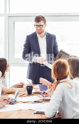 Startup business team sulla riunione di moderno luminoso ufficio brainstorming interiore, lavorando sul laptop e tablet pc Foto Stock