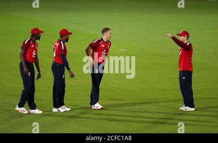 Il capitano inglese Eoin Morgan (a destra) parla di tattiche con Jofra Archer, Chris Jordan e Tom Curran (a sinistra-destra) durante la prima partita di Vitality IT20 all'Ageas Bowl, Southampton. Foto Stock