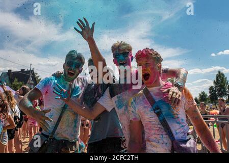 Polonia, 2020 luglio: Giovani felici che si godono Holi Festival, festeggiando festival di colori lanciando polvere colorata in aria Foto Stock