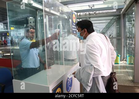 Kolkata, India. 03 settembre 2020. Un dipendente dell'aeroporto che indossa il visiera controlla la temperatura corporea di un passeggero all'aeroporto internazionale Netaji Subhas Chandra Bose di Kolkata. Delhi, Mumbai, Chennai, Ahmedabad, Pune e Nagpur sono permessi in modo limitato da settembre. Saranno ammessi martedì, giovedì e domenica durante la prima e la seconda settimana di settembre", ha detto l'aeroporto di Kolkata in una dichiarazione. (Foto di Dipa Chakraborty/Pacific Press/Sipa USA) Credit: Sipa USA/Alamy Live News Foto Stock