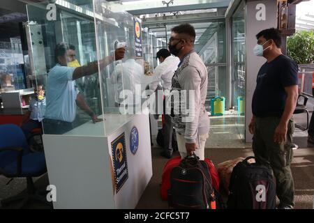 Kolkata, India. 03 settembre 2020. Un dipendente dell'aeroporto che indossa il visiera controlla la temperatura corporea di un passeggero all'aeroporto internazionale Netaji Subhas Chandra Bose di Kolkata. Delhi, Mumbai, Chennai, Ahmedabad, Pune e Nagpur sono permessi in modo limitato da settembre. Saranno ammessi martedì, giovedì e domenica durante la prima e la seconda settimana di settembre", ha detto l'aeroporto di Kolkata in una dichiarazione. (Foto di Dipa Chakraborty/Pacific Press/Sipa USA) Credit: Sipa USA/Alamy Live News Foto Stock