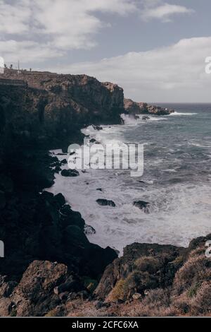 Pittoresco mare di costa con enormi scogliere e potente oceano Onde che si infrangono sull'isola di Tenerife Foto Stock