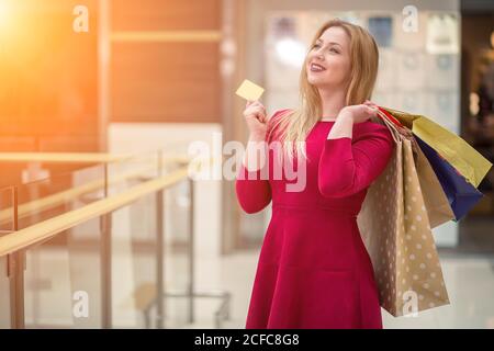 Donna che mantiene la carta di credito, Shopping Bag, in shoping mall. Foto Stock