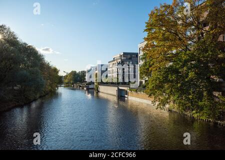 Ammira la vista panoramica sul canale Osterbek e sulle moderne case cittadine lungo il canale dal pittoresco Großheidesteg, nel quartiere Winterhude di Amburgo. Foto Stock