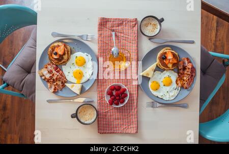 Deliziose uova fritte con pancetta e formaggio a colazione Foto Stock