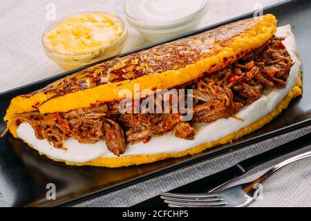 Cachapa, tipico piatto venezuelano a base di mais e farcito con formaggio bianco e carne alla griglia Foto Stock