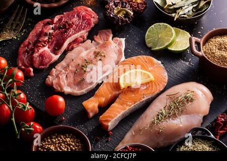 Piatto di proteine circondato da spezie e condimenti tabella Foto Stock