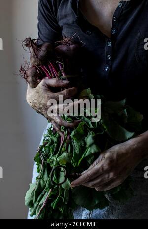 persona senza volto con mazzo di barbabietole e chiave Foto Stock