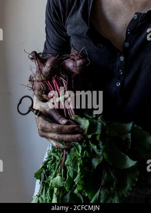 persona senza volto con mazzo di barbabietole e chiave Foto Stock