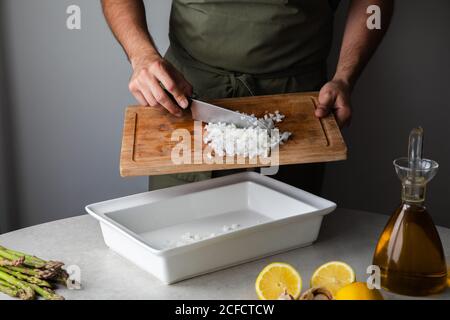 Cuocere mettendo la cipolla tagliata nel vassoio Foto Stock