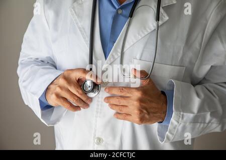 L'infermiere regola il fonendoscopio sul collo del medico Foto stock - Alamy