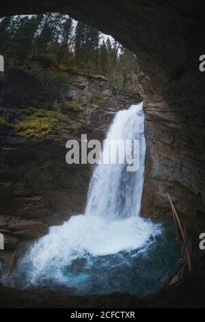 Roccia con ruscello a cascata in lunga esposizione. Scatto verticale all'aperto. Foto Stock