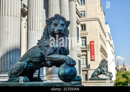 Un paio di grandi statue di leoni leggono i gradini di un edificio governativo nel centro di Madrid, in Spagna. Foto Stock