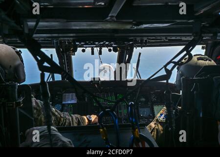 301st i piloti di Rescue Squadron posizionano il loro elicottero Hawk pave HH-60G per collegarsi con l'aereo HC-130J Combat King II per iniziare il rifornimento aria-aria sull'Oceano Atlantico 3 settembre 2020. Gli aeromobili sono assegnati alla 920esima ala di salvataggio situata sulla base dell'aeronautica di Patrick, la Fla. Il salvataggio dell'aeronautica è l'unica entità del DoD specificamente organizzata, addestrata ed equipaggiata per condurre le operazioni di recupero del personale nelle zone ostili o negate come missione primaria. (STATI UNITI Air Force foto di Tech. SGT. Kelly Goonan) Foto Stock