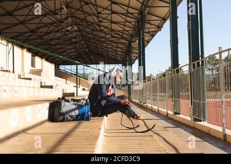 Atleta maschile con gamba protesica seduta sulle scale Foto Stock