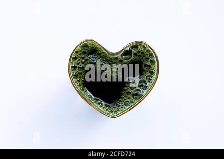 Il bicchiere a forma di cuore di gotu kola lascia il succo per la salute su sfondo bianco. Spazio di copia Foto Stock