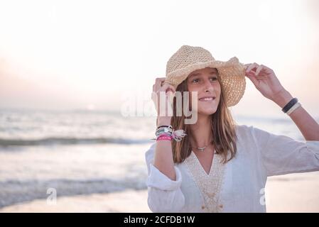 Donna di charme in vestito bianco chiaro sulla spiaggia ondulata Foto Stock