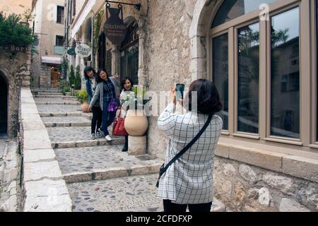 Saint-Paul-de-Vence Francia Gruppo selfie. Istantanea di tre grazie. La ragazza giapponese sta scattando una foto delle sue fidanzate nella città vecchia. Foto Stock