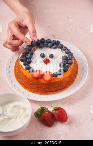 donna senza volto che serve torta con frutti di bosco Foto Stock