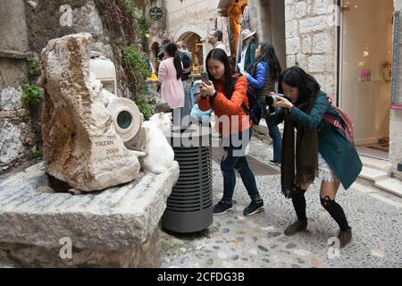 Saint-Paul-de-Vence i turisti giapponesi sono fotografi diligenti. La statua in marmo bianco di Luc Trisan è un bersaglio popolare, anche il gatto bianco. Foto Stock