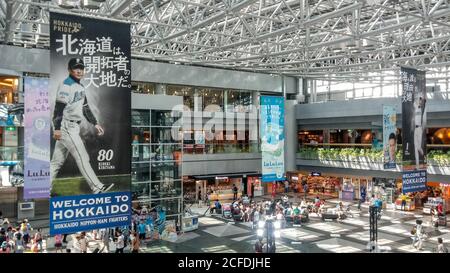 Sapporo, Hokkaido, Giappone - atrio del terminal nazionale dell'aeroporto di New Chitose. Banner pubblicitari appesi su Sapporo Beer e Nippon-Ham Fighters. Foto Stock