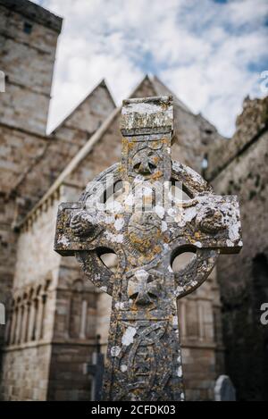 Croce celtica di fronte alla Cappella di Cormac, Rocca di Cashel, Irlanda Foto Stock