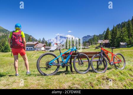 Donna che si trova di fronte al monte Civetta, vicino al cherz alm, tour con e-bike nel paesaggio naturale delle Dolomiti, livinallongo del col di lana, Foto Stock