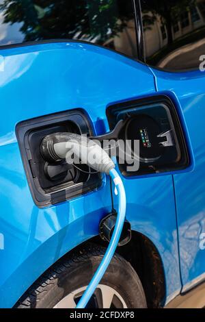 Essen, Nord Reno-Westfalia, Germania - l'auto elettrica è a pagamento in un parcheggio con cavo di ricarica presso una stazione di ricarica. Foto Stock