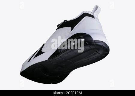 Sneaker bianche con dettagli neri su una suola nera. Scarpe sportive. Foto Stock