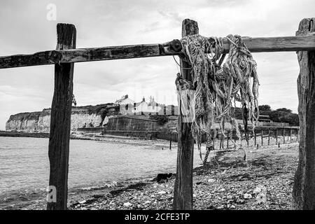 I famosi cottage della guardia costiera sulle scogliere che si affacciano su Cuckmere Haven Presso la riserva naturale Seaford Head incorniciata da una vecchia corda lavata sulla bera di legno Foto Stock