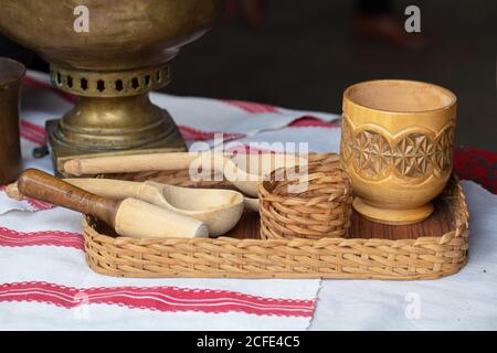 Cucchiaio etnico di legno e tazza su un vassoio di viti Foto Stock