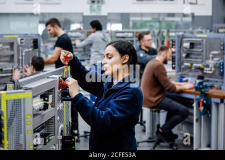 Remscheid, Renania Settentrionale-Vestfalia, Germania - tirocinante donna nelle professioni elettriche, un elettricista industriale assembla un circuito, professionale Foto Stock