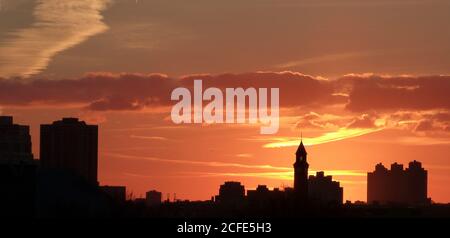 Spettacolari silhouette scure degli edifici al tramonto, New York. Spettacolare tramonto rosso. Nuvole arancioni. Cieli brucianti. Cielo panoramico celeste. Cielo colorato. Foto Stock