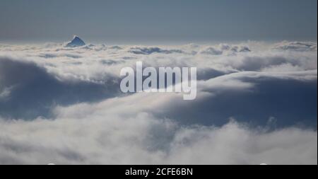 Vista dalla cima Zugspitze (Zugspitze) in inverno sul mare di nuvole e una suggestiva cima di montagna, alta nebbia, nuvole, Grainau, Foto Stock