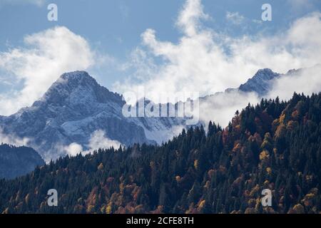 Picco di montagna Oberreintalschrofen nelle montagne di Wetterstein, nuvole, cielo blu, alberi, autunno, Garmisch-Partenkirchen, alta Baviera, Baviera, Foto Stock