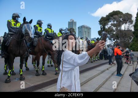 Melbourne, Australia 5 settembre 2020, una protesta femminile prende un selfie davanti a cavalli di polizia al Freedom Day Anti-maschera e anti-blocco protesta al Santuario della memoria a Melbourne Australia. Credit: Michael Currie/Alamy Live News Foto Stock