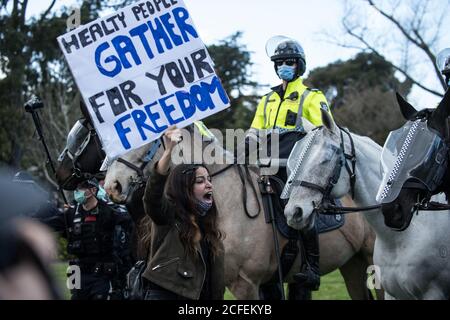 Melbourne, Australia 5 settembre 2020, una donna protestore tiene il suo placard aloft mentre si alza il terreno di fronte a cavalli di polizia al Freedom Day Anti-maschera e anti-blocco protesta al Santuario della memoria a Melbourne Australia. Credit: Michael Currie/Alamy Live News Foto Stock