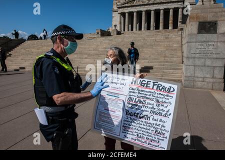 Melbourne, Australia 5 settembre 2020, una protestante femminile tiene i suoi cartelli mentre parla con un ufficiale di polizia al Freedom Day Anti-maschera e anti-blocco protesta sui passi del Santuario della memoria a Melbourne Australia. Credit: Michael Currie/Alamy Live News Foto Stock