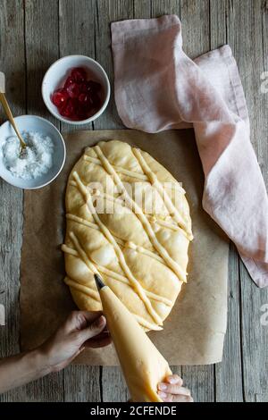 Vista dall'alto della pasticceria fresca Coca de San Juan tavolo in legno in cucina rustica Foto Stock