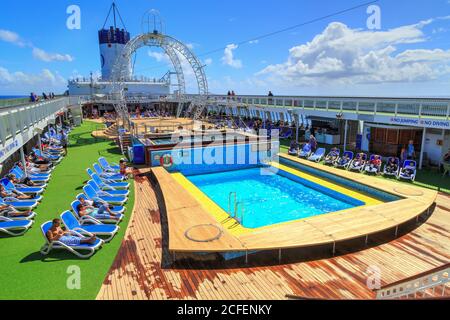 I passeggeri si godano il sole sulla terrazza della piscina di una nave da crociera. Fotografato a bordo del P&o Liner 'Pacific Jewel', 3/22/2018 Foto Stock