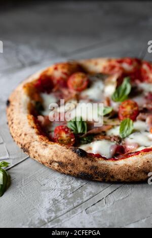 Deliziosa pizza estiva fresca posta su tavola in rustico cucina Foto Stock