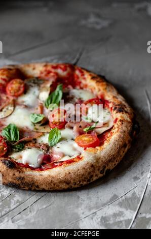 Deliziosa pizza estiva fresca posta su tavola in rustico cucina Foto Stock