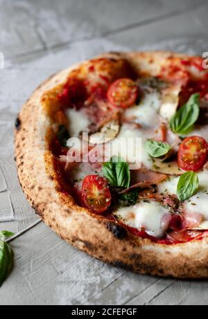 Deliziosa pizza estiva fresca posta su tavola in rustico cucina Foto Stock