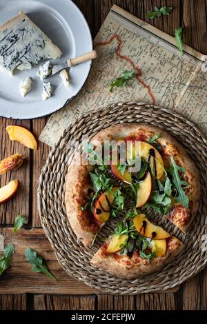 Deliziosa pizza estiva fresca posta su tavola in rustico cucina Foto Stock