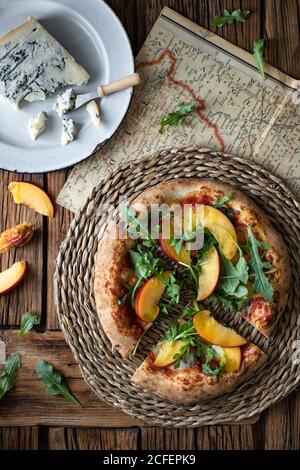 Deliziosa pizza estiva fresca posta su tavola in rustico cucina Foto Stock