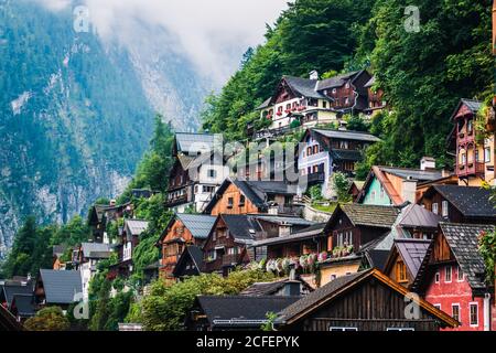 Case accoglienti di piccolo insediamento situato vicino alla foresta sulla montagna Pendenza su nuvoloso giorno in Austria Foto Stock